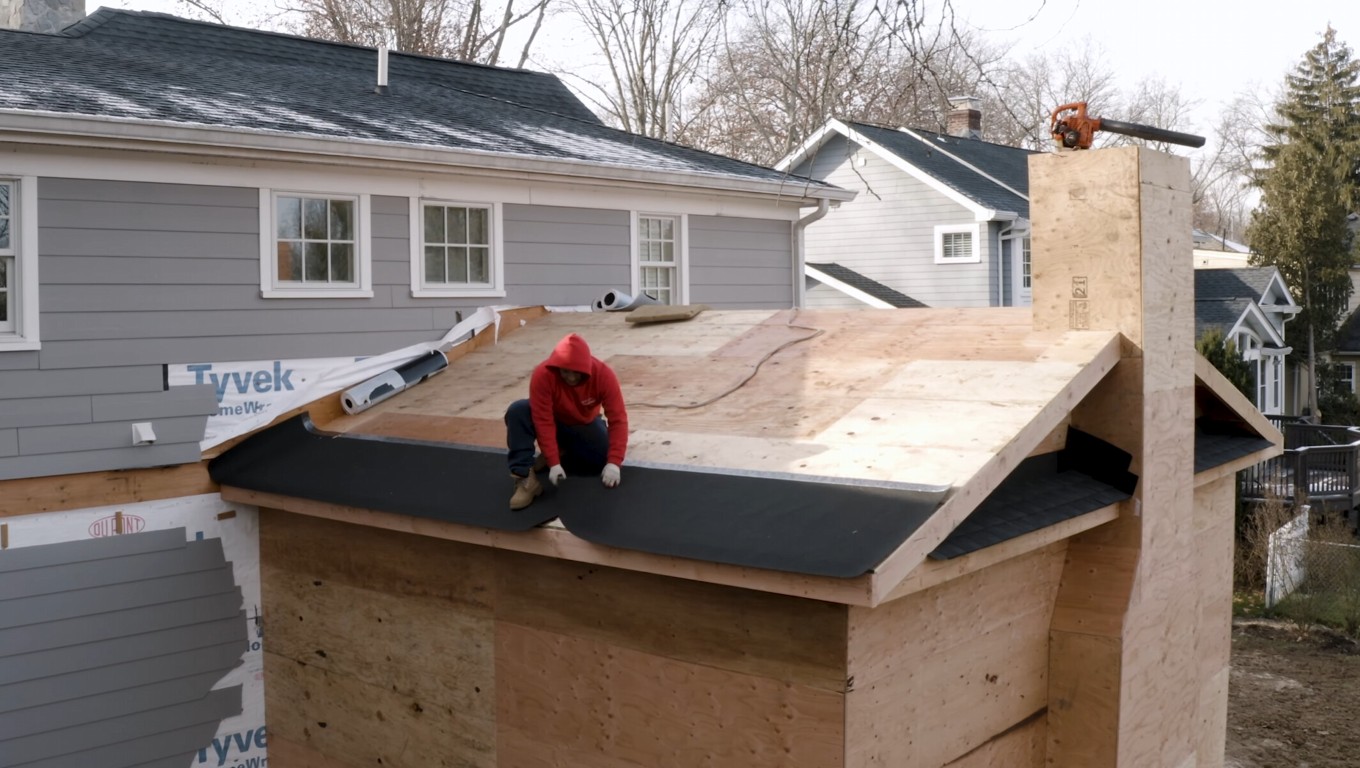 Worker installing roofing for outdoor patio cover structure